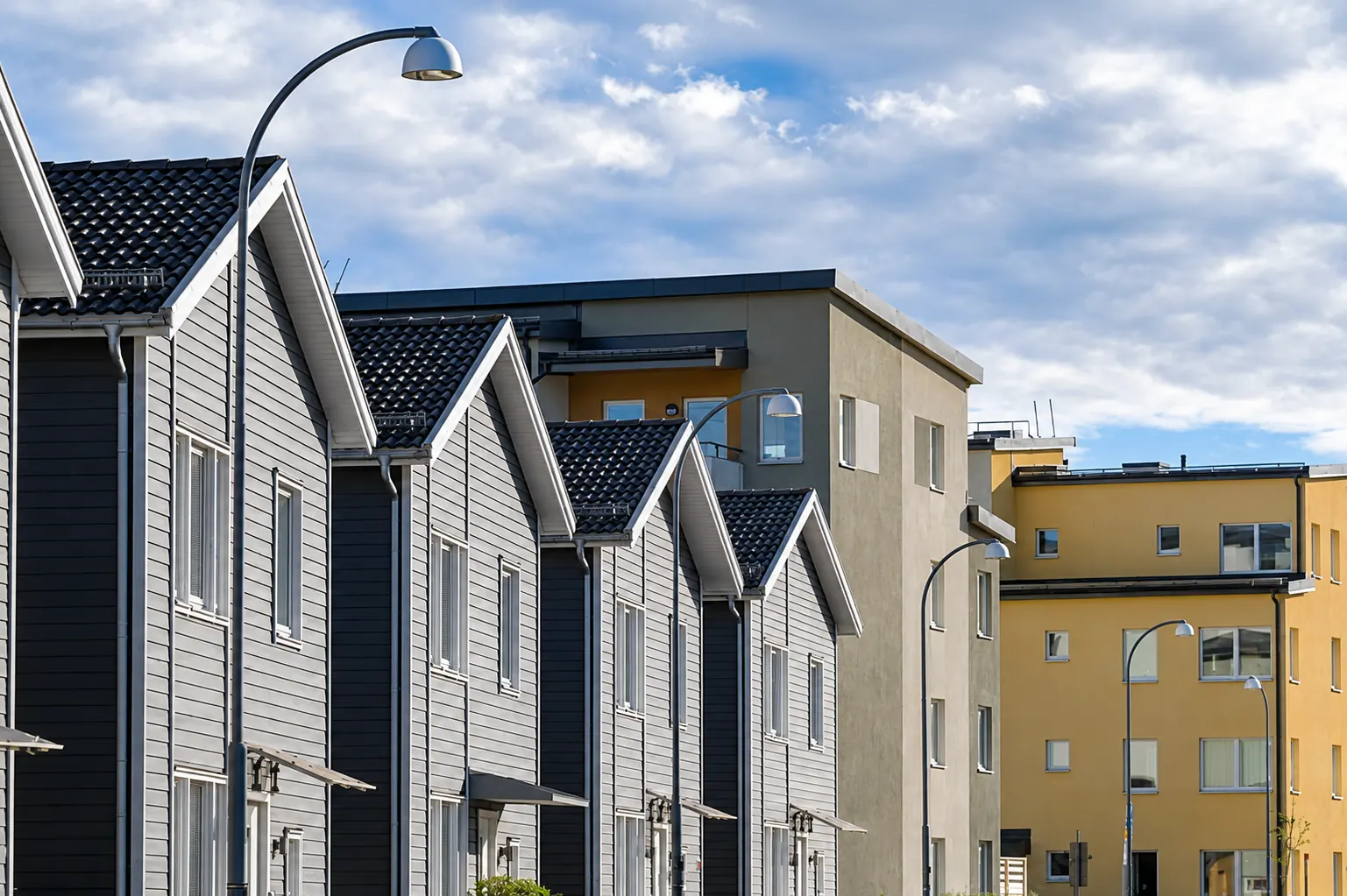 Row of Surrey townhouses with gutters and downspouts along a shared roofline